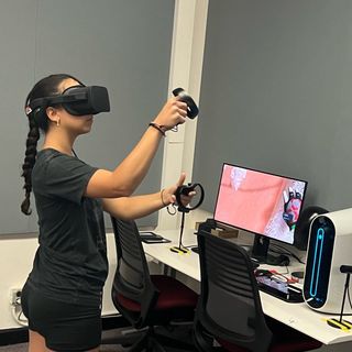 Picture of student using a virtual reality headset to climb (using The Climb app)